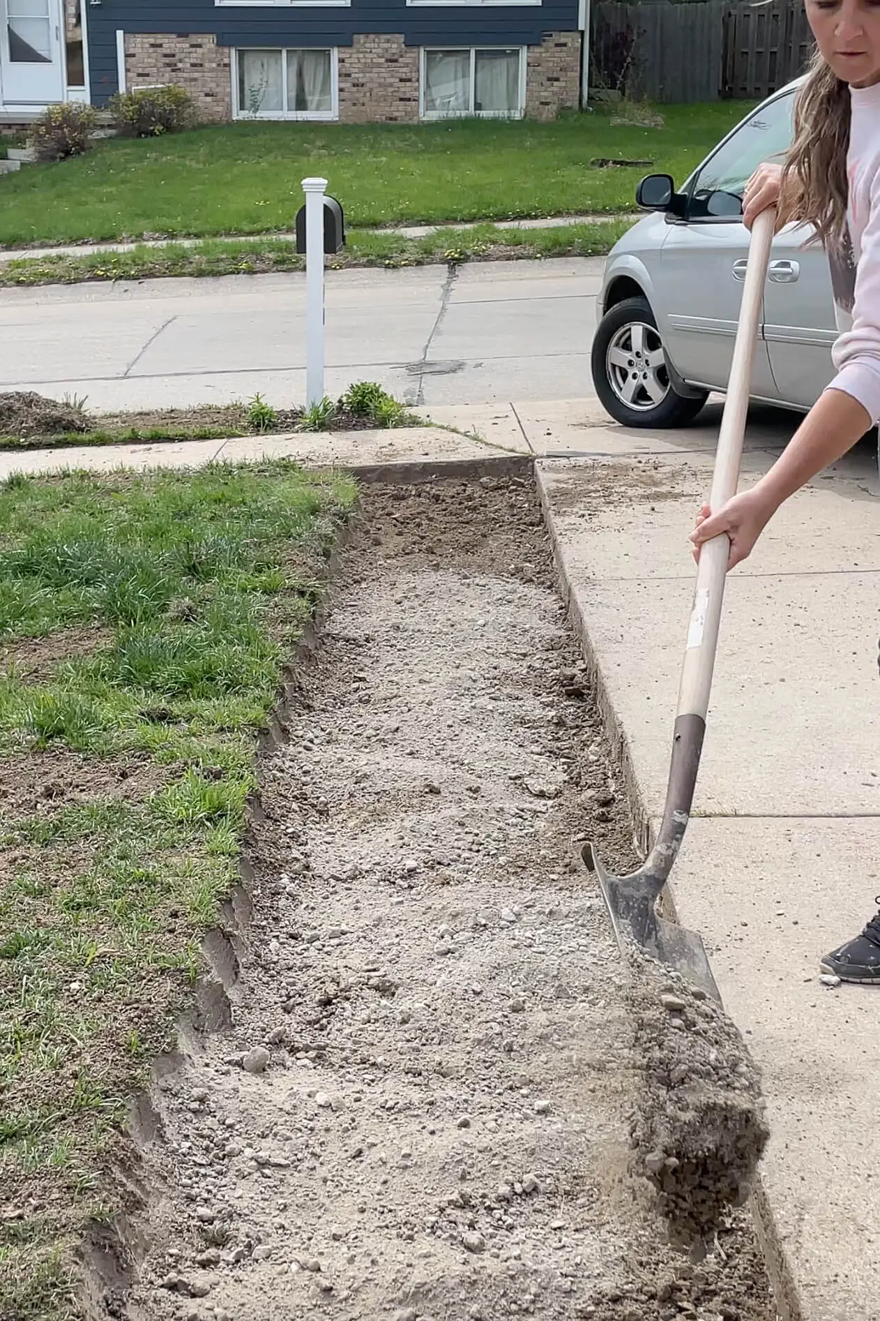 Laying road base down before adding a paver driveway extension.
